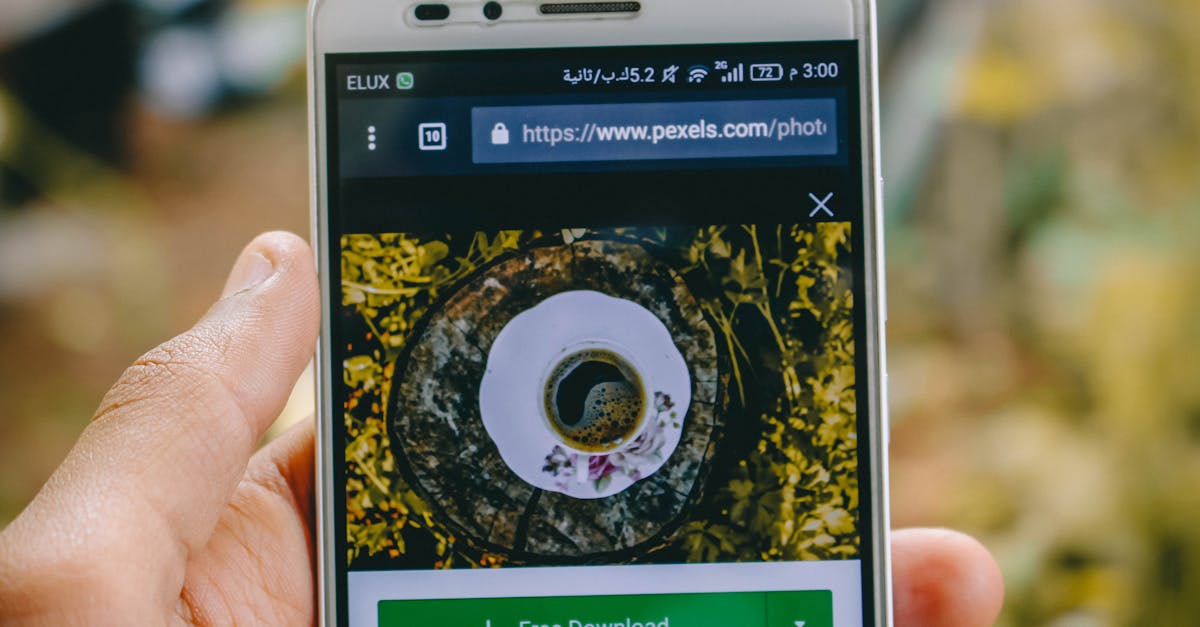 Close-up of a smartphone showing a coffee cup image on a screen outdoors.