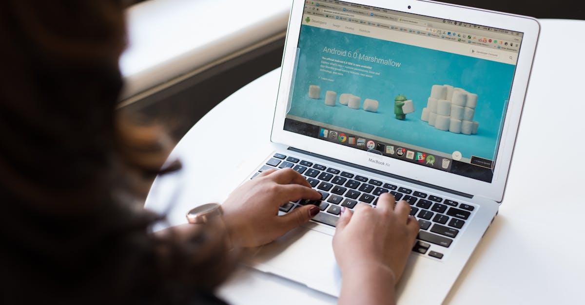 Businesswoman working on laptop with Android 6.0 Marshmallow webpage open.