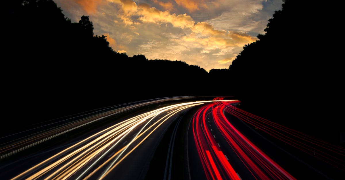 Dramatic long exposure of highway light trails beneath colorful twilight sky in Mönchengladbach, Germany.